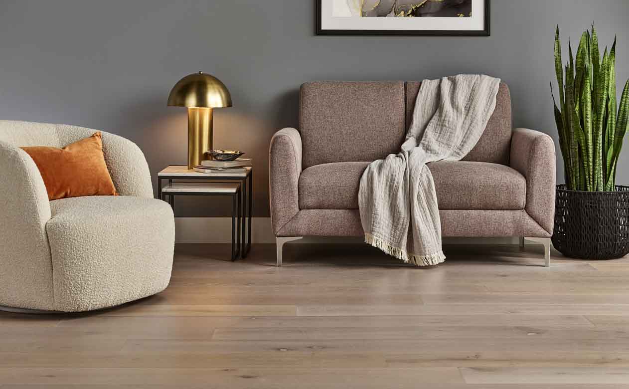 Hardwood Flooring in Living Room with boucle chair, beige couch and gold lamp